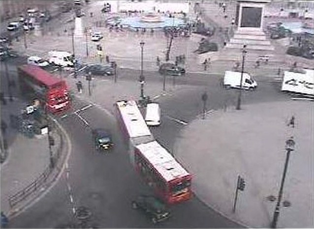 Première séquence, capture d'une webcam publique de Londres&nbsp;: vue en plongée d'un carrefour de Trafalgar Square, l'image grise et granuleuse d'une caméra fixe. Deux bus rouges à impériale amorcent le virage au centre, une camionnette blanche traverse, des piétons minuscules longent les trottoirs&nbsp;; à droite, le socle d'une colonne et le bassin d'une fontaine.